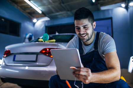 Young male car mechanic using a digital tablet.の写真素材