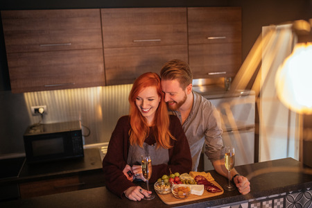 Shot of a happy young couple enjoying spending time home while eating healthy dinner and drinking wine.の写真素材
