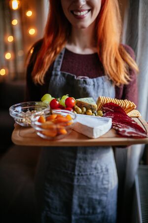 Shot of a young beautiful girl serving breakfast on a wooden plate.の写真素材