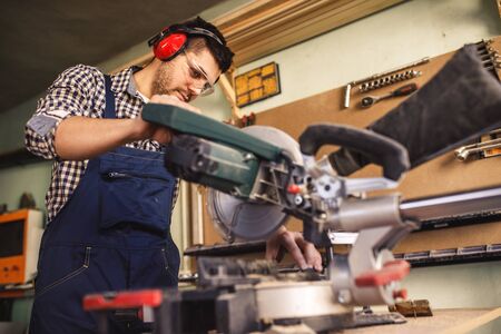 Photo of a young carpenter working in workshop.の写真素材