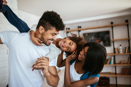 Happy african american family having fun at home.の写真素材