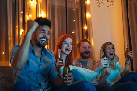 Photo of friends enjoying watching a game at home.の写真素材