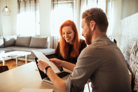 Portrait of two happy friends working on a project at home.の写真素材