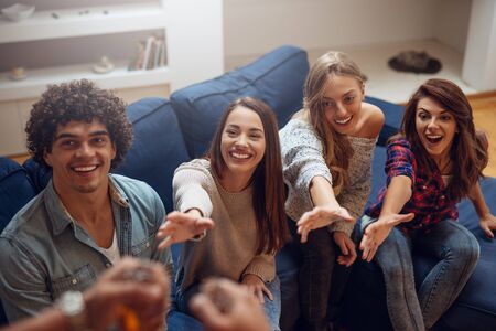 Photo of a happy group of friends waiting for beer in the living room.の写真素材