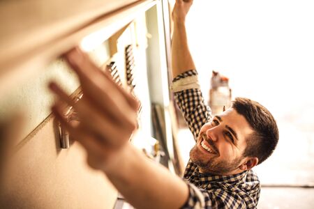 A handsome young carpenter taking measurements of some wood.の写真素材