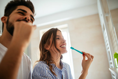 Portrait of a happy couple having fun while brushing teeth in the bathroom.