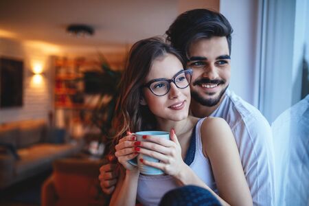 Portrait of a happy young couple cuddling at home.の写真素材