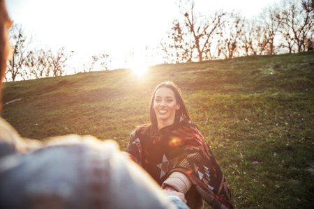 Happy couple in love having fun in the park at sunset.