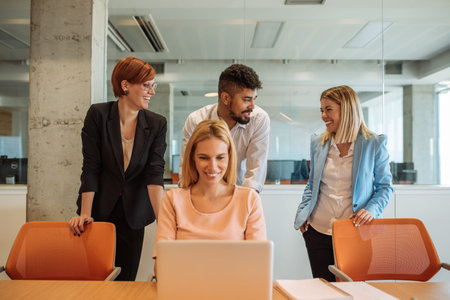 Photo of happy colleagues enjoying working together in the office.