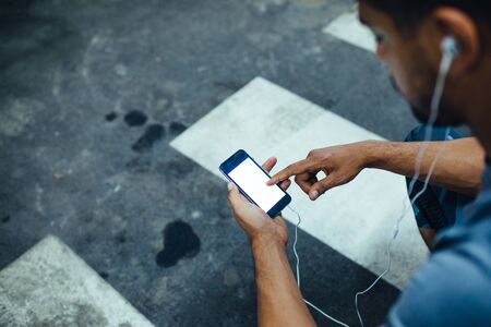 Shot of an athlete male using mobile phone during workout.の写真素材