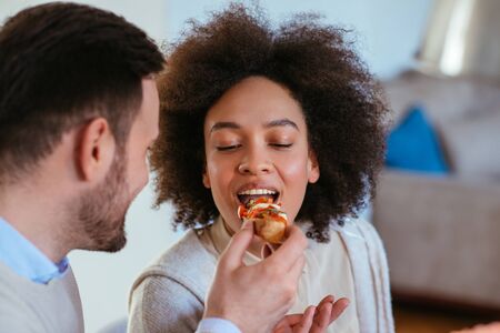 Shot of young man feeding his girlfriend.の写真素材