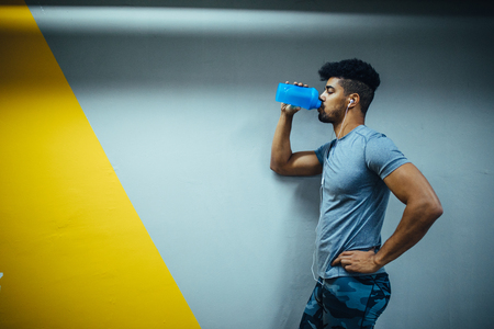 Portrait of african american young athlete man drinking water.の写真素材