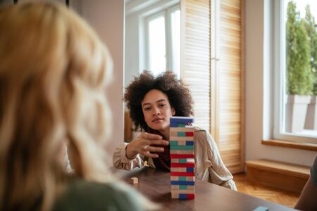 Portrait of young woman playing a game with friends at home.の写真素材