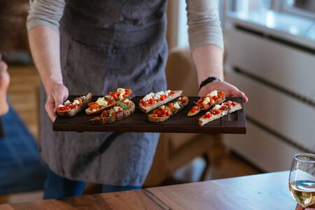 Photo of a young man serving food.の写真素材