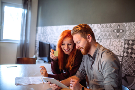 Photo of a happy couple enjoying buying over the internet.の写真素材