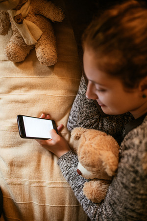 Close up photo of a teenage girl using mobile phone.の写真素材
