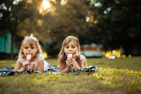 Sisters eating an icecream while enjoying time together.の写真素材