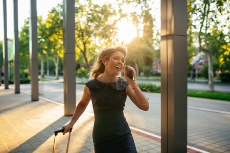 Attractive woman singing on the phone outdoors.の写真素材