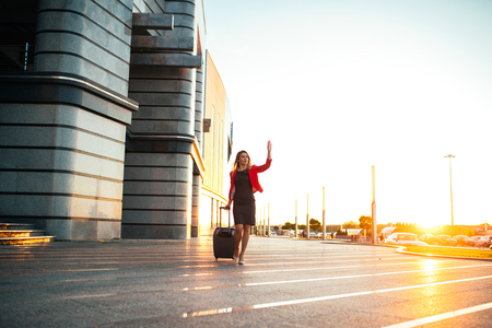 Attractive elegant woman calling a cab on the airport.の写真素材