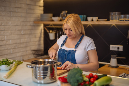 Photo of a woman cooking a healthy dish in the kitchen.の写真素材