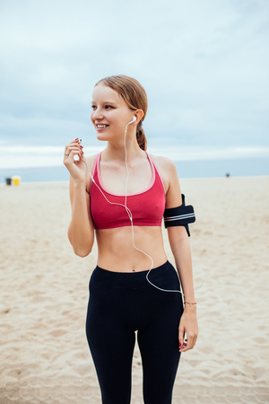 Beautiful young woman setting her running playlist.の写真素材