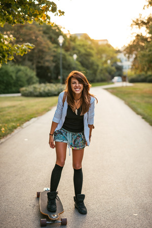 Young and beautiful girl driving skate outdoors.の写真素材
