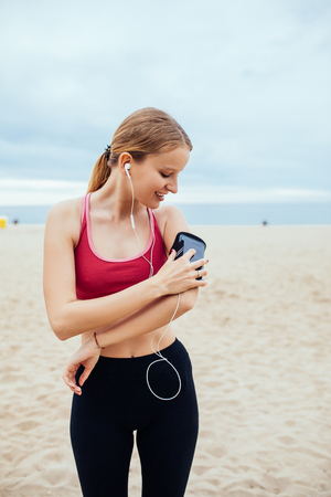 Beautiful young woman setting her running playlist.の写真素材