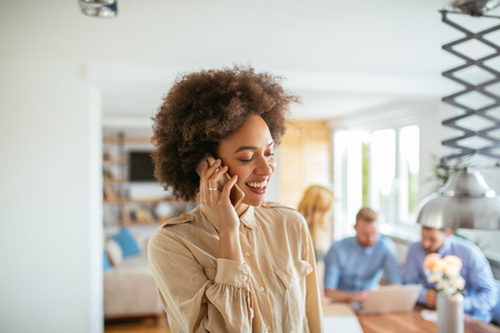 Photo of a smiling young businesswoman talking on the mobile phone.の写真素材