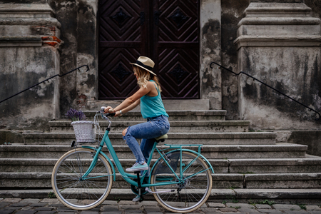 Beautiful woman driving a bike in the city.の写真素材