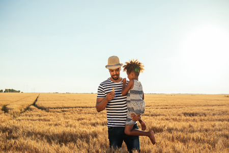 Photo of an african american father and daughter having fun in the fields.の写真素材