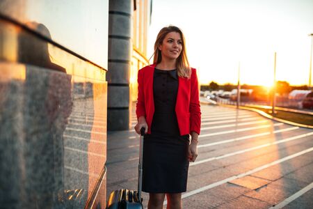 Shot from above of a confident young business woman standing with suitcase.の写真素材