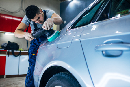 Portrait of a young serviceman polishing a car.の写真素材