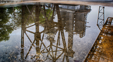 Photograph of an industrial structure reflected on a puddleの写真素材