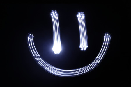 Photograph of a happy face drawing made with long exposure light effectの写真素材