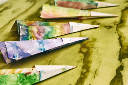 Photograph of some paper colorful planes on a wood tableの写真素材