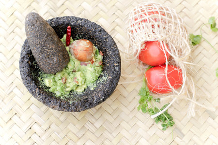 Photograph of smashed advocado, guacamole in a traditional stone molcajeteの写真素材