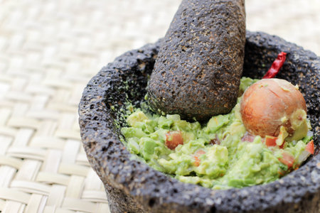 Photograph of smashed advocado, guacamole in a traditional stone molcajeteの写真素材
