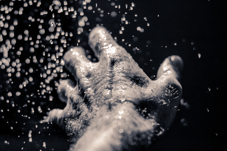 Photograph of an open human hand under water dropsの写真素材
