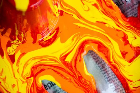 Photograph of some paint pouring out and spilling on a paperの写真素材