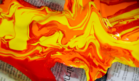 Photograph of some paint pouring out and spilling on a paperの写真素材