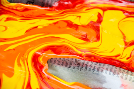 Photograph of some paint pouring out and spilling on a paperの写真素材