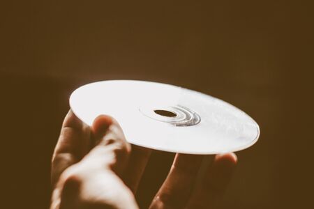 Photograph of a human hand holding a cpmpact diskの写真素材