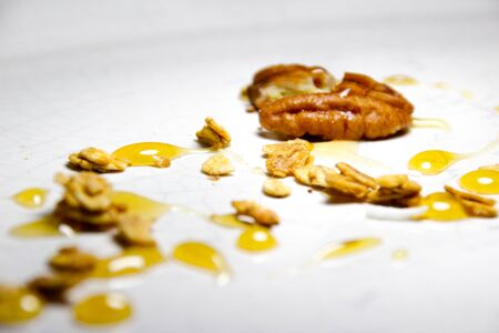 Photograph of a closeup of a plate with a granola, honey and nut dessertの写真素材