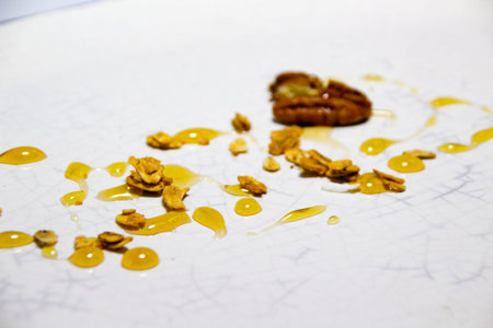 Photograph of a closeup of a plate with a granola, honey and nut dessert