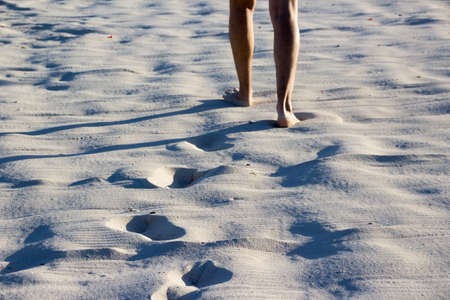Photoraph of beach sand with a person walking and foot printsの写真素材