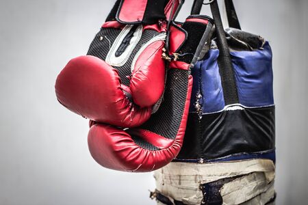 Photograph of an old punching bag and a pair of boxing glovesの写真素材