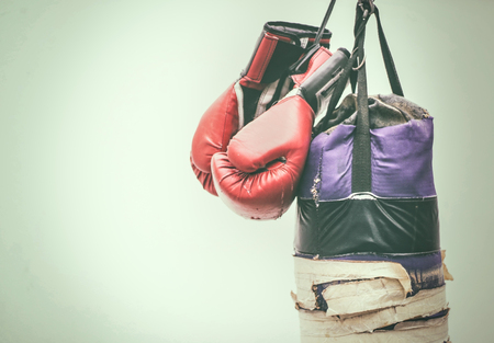 Photograph of an old punching bag and a pair of boxing glovesの写真素材