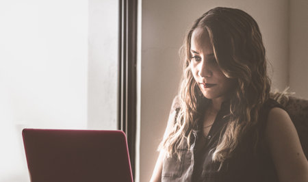 Photograph of a young modern woman working at her laptop