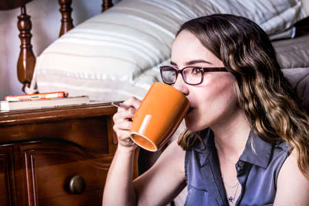 Photograph of a young modern woman drinking coffeeの写真素材