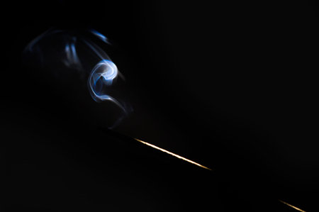 Photograph of an Incense bar and smoke on dark background